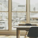 作者刘建国在书桌前整理资料的近照，桌上摊着笔记本与便签