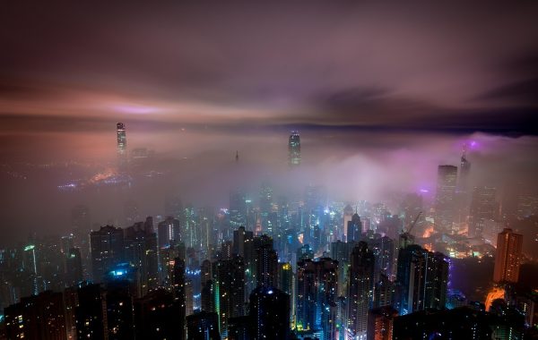 南方城市夜晚的出租屋一角，暖色台灯下屏幕微亮，桌上放着热茶与除湿盒